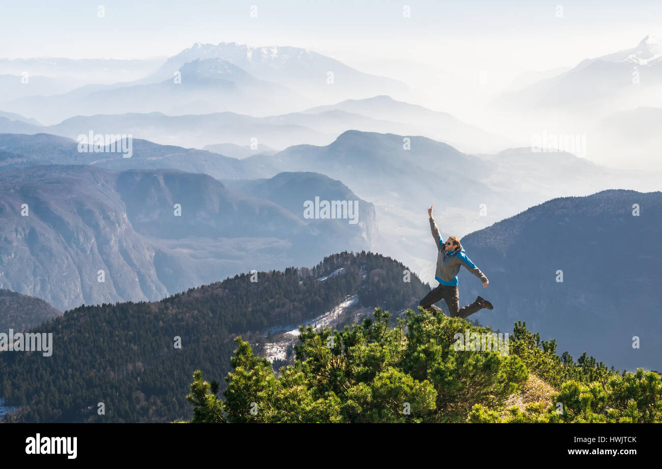 Felice successo uomo vincente sul vertice di montagna salti di gioia Foto Stock