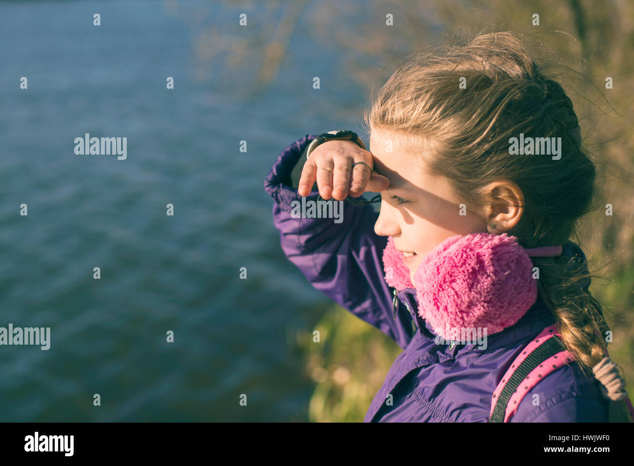 Bambino ragazza sulla riva guardando lontano dalla primavera Foto Stock