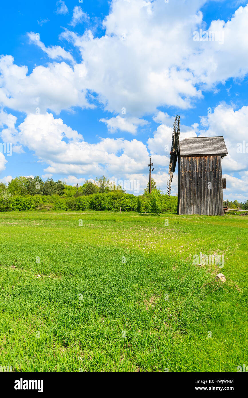 Vecchio mulino a vento di legno sul campo verde nella primavera del paesaggio del villaggio Tokarnia, Polonia Foto Stock