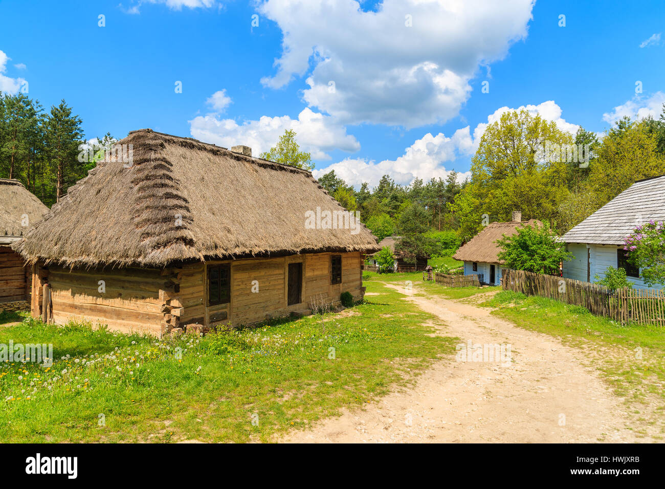 Vecchie case tradizionali con tetti di paglia nel villaggio Tokarnia sulla soleggiata giornata di primavera, Polonia Foto Stock