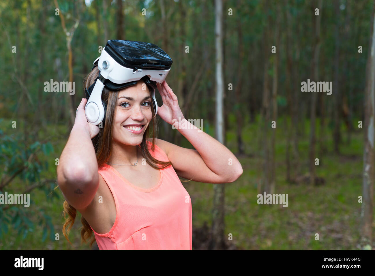 Bella donna con la realtà virtuale nel parco all'aperto. VR occhiali cuffie dispositivo. Foto Stock