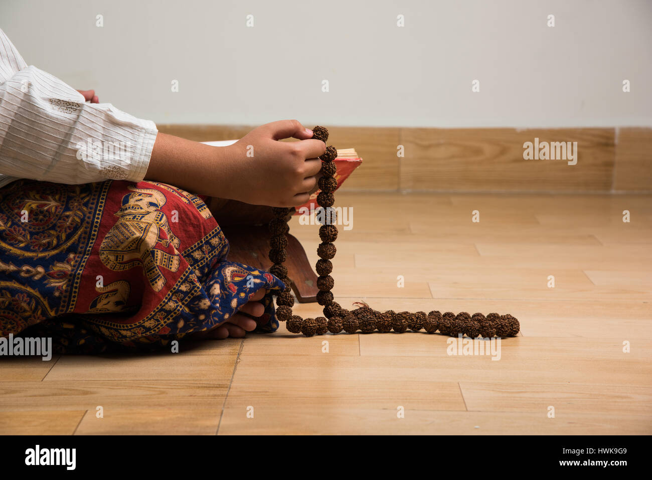 Primo piano immagine della mano mentre facendo meditazione con rudraksha mala o del rosario, la messa a fuoco selettiva Foto Stock