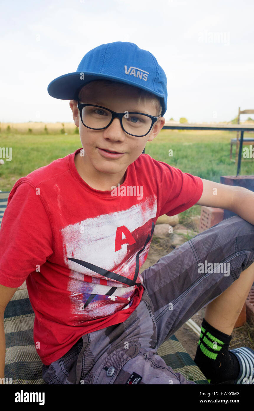 Ragazzo intelligente seduta su una poltrona indossando un cappello furgoni con un gufo sapiente look. Il polacco kid età 12. Zawady Polonia centrale Europa Foto Stock