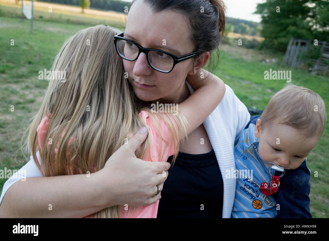 Madre figlia confortante mentre si tiene il suo bambino figlio. Lucidare la mamma e i suoi bambini di età di 8, 38 e 7 mesi. Zawady Polonia centrale Europa Foto Stock