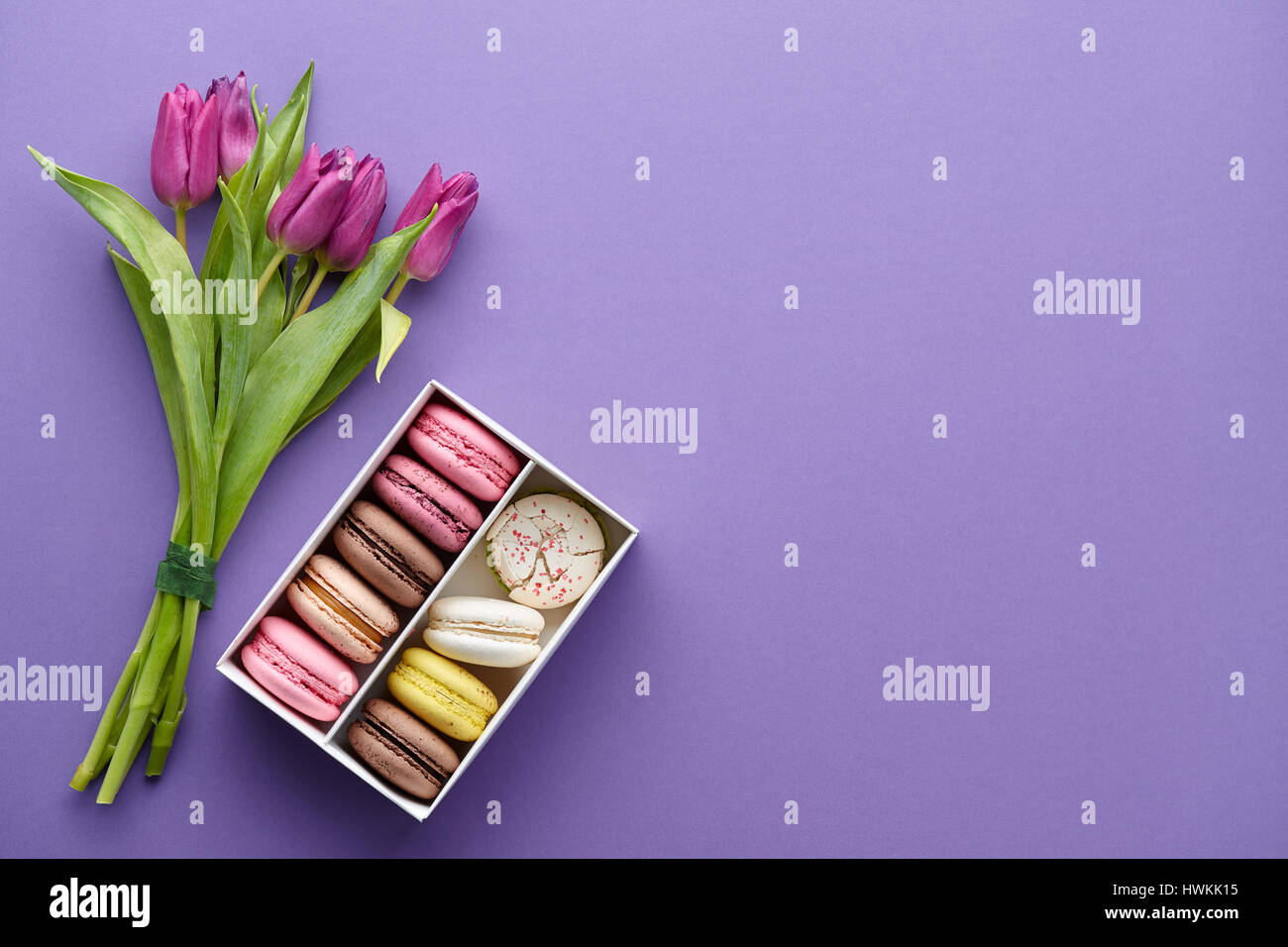 Viola tulipani e una scatola di macarons Foto Stock
