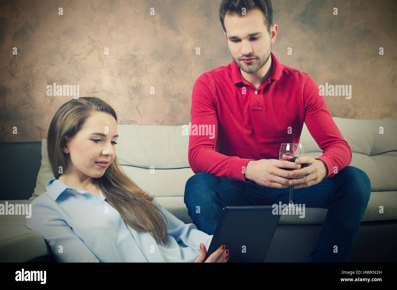 Coppia trascorre il tempo libero. Donna con una pastiglia in mani. donna tablet tenendo dietro il lifestyle leisure piscina giovane concetto Foto Stock
