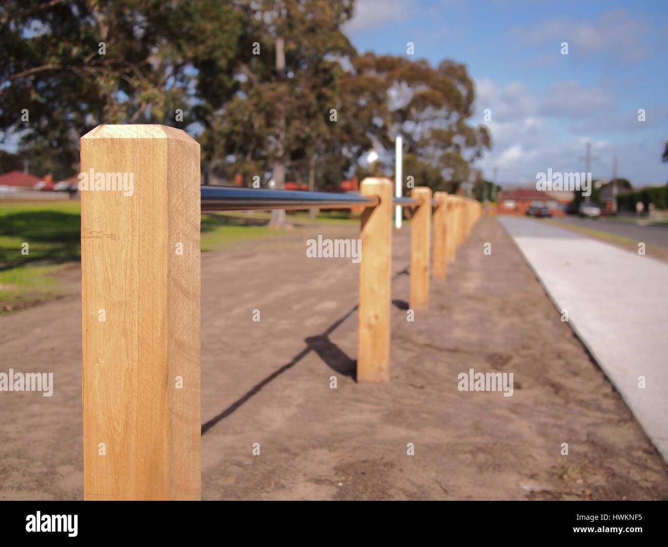 Barriera di legname pole e tubo di barriera tra una strada e un parco pubblico, Australia 2016 Foto Stock