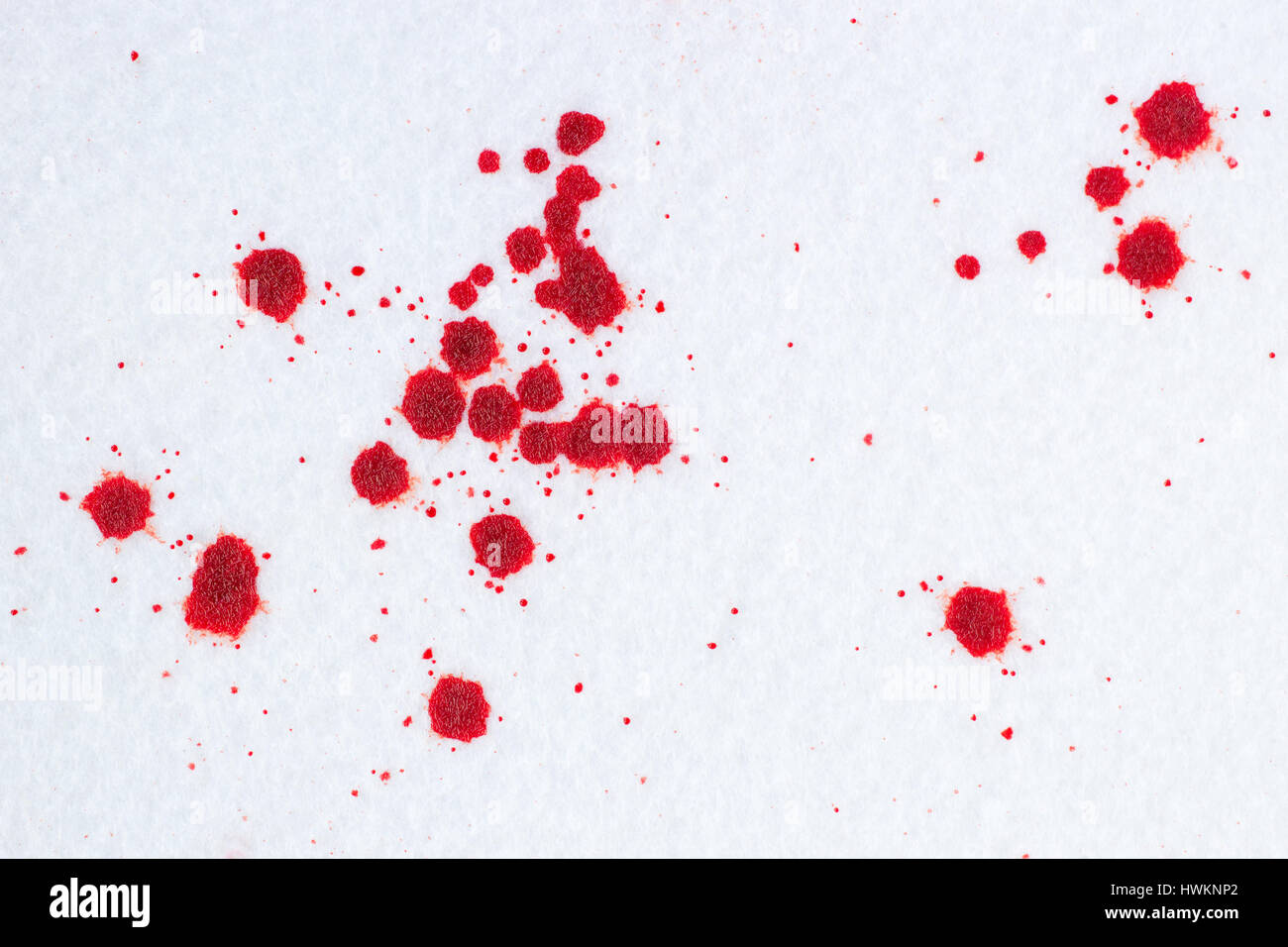 Rosso gocce di sangue sulla neve bianca-piaciuto lo sfondo in feltro. Penale o il concetto di violenza Foto Stock
