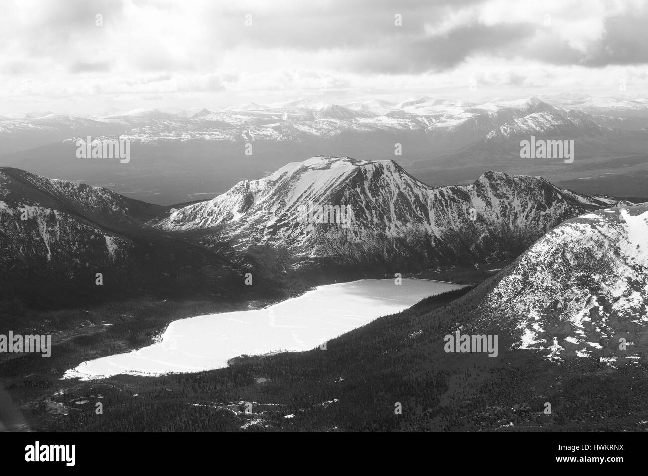 Vista aerea di un lago ghiacciato in mezzo a montagne ad ovest di Whitehorse, Yukon, Canada Foto Stock