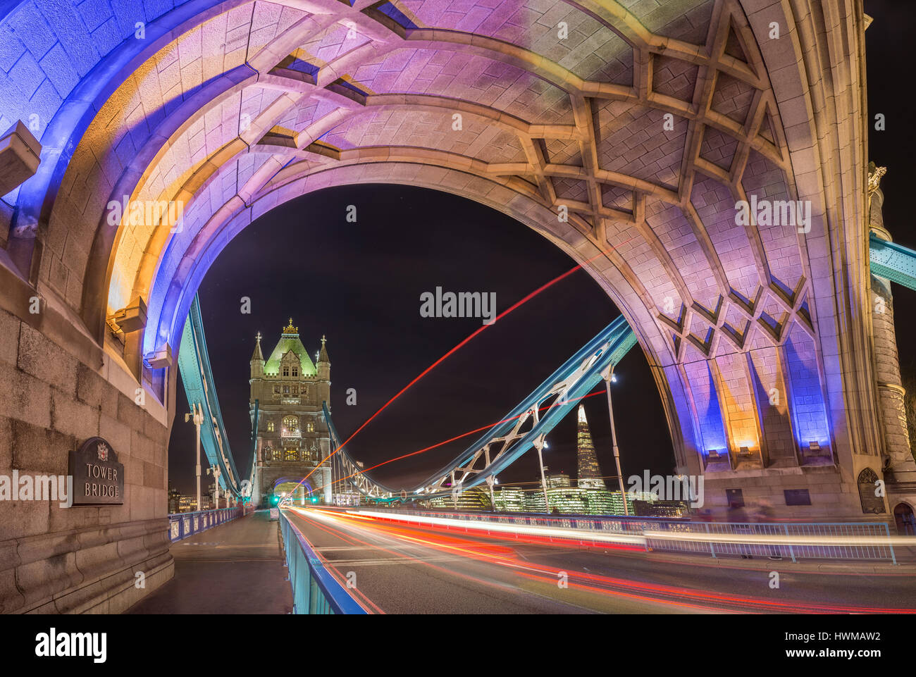 Londra, Inghilterra - Night Shot della famosa in tutto il mondo colorato il Tower Bridge di Londra con double decker bus sentieri di luce e di uffici e di Shard grattacielo Foto Stock