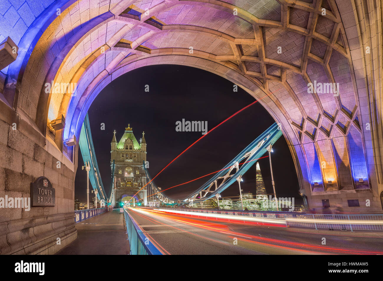 Londra, Inghilterra - Night Shot della famosa in tutto il mondo colorato il Tower Bridge di Londra con double decker bus sentieri di luce e di uffici e di Shard grattacielo Foto Stock