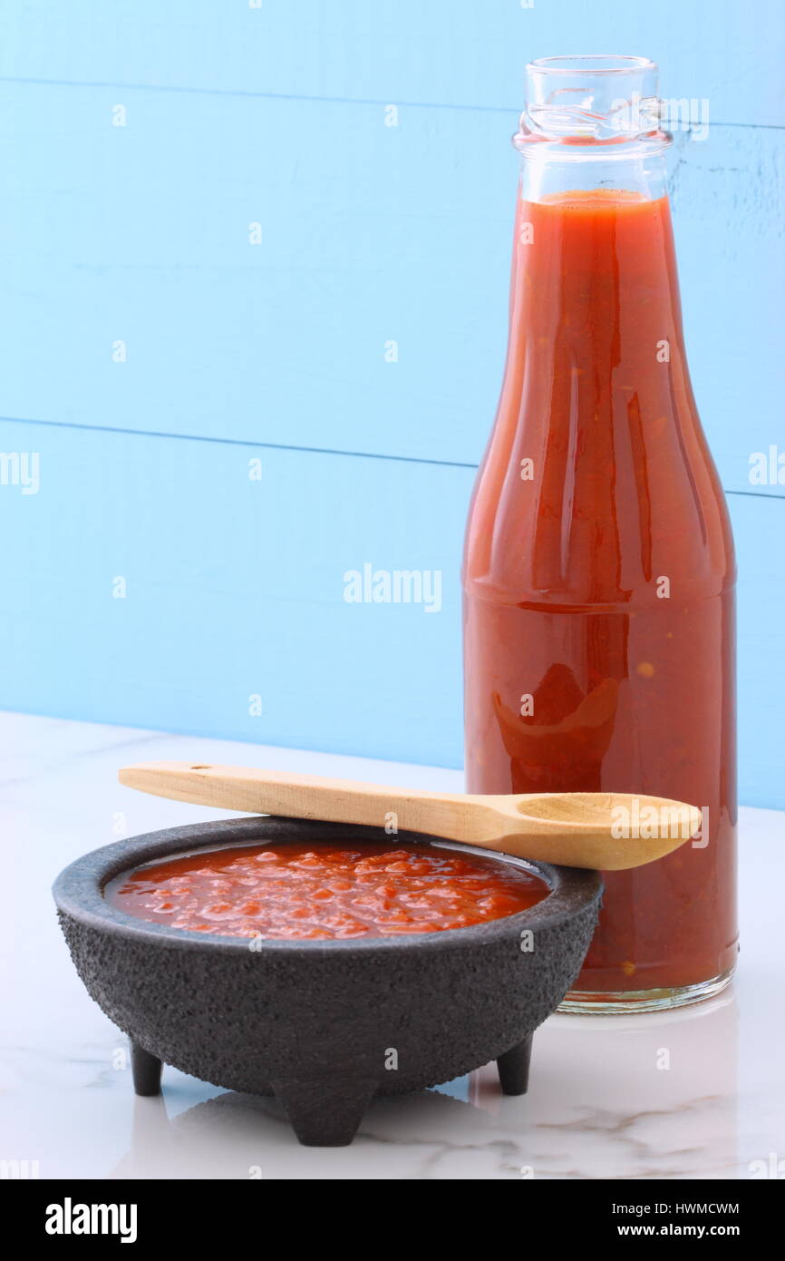 Artigiano messicano salsa calda in vintage talavera ciotola con un delizioso dolce sapore caldo, su vintage in marmo di carrara tavolo. Foto Stock