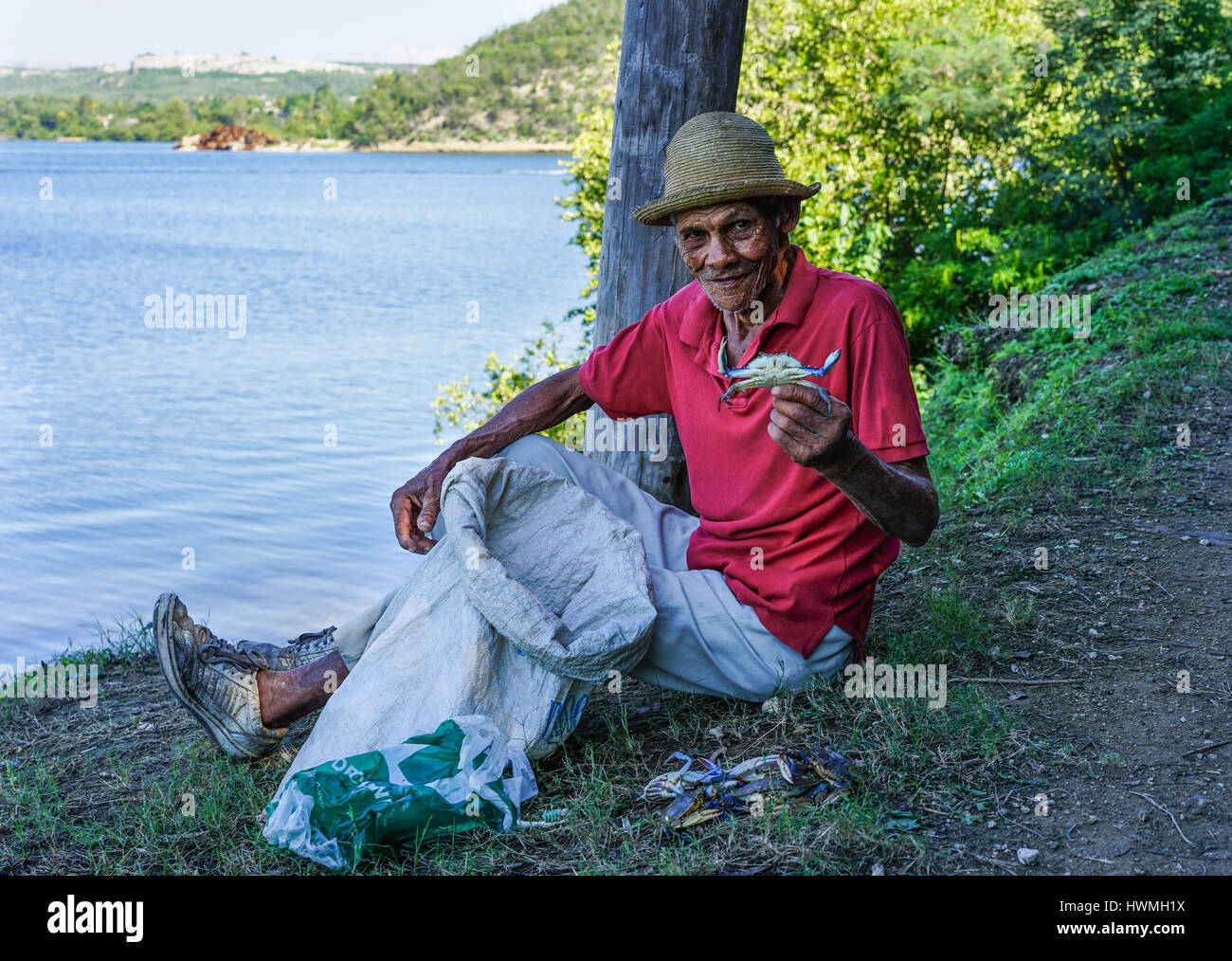 Cayo Granma, Santiago de Cuba. Cuba - 11 Gennaio 2016: il vecchio uomo cubano che ha pescato granchi e visualizza del pescato del giorno. Indossa il cappello di paglia come pro Foto Stock