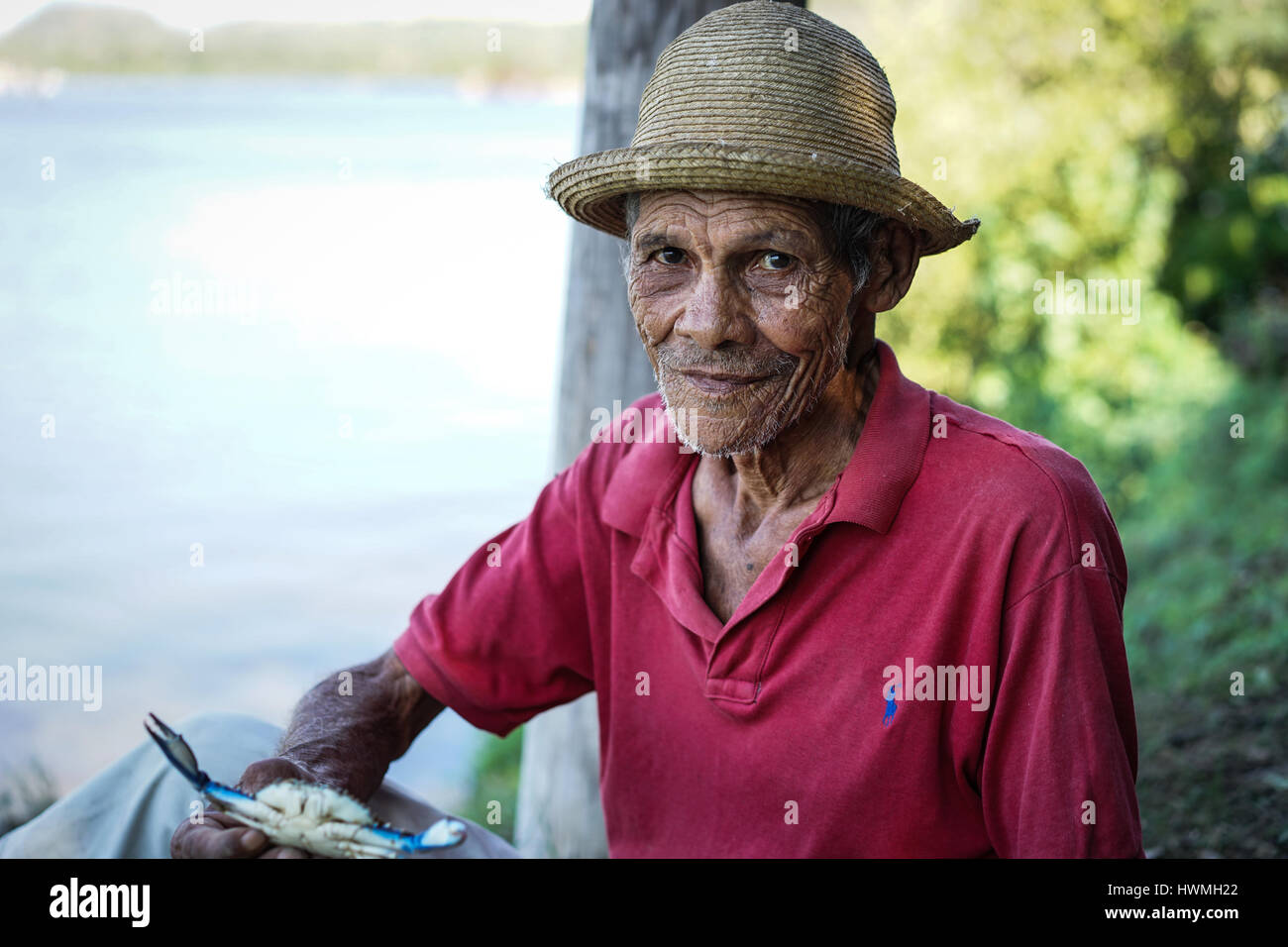 Cayo Granma, Santiago de Cuba. Cuba - 11 Gennaio 2016: il vecchio uomo cubano che ha pescato granchi e visualizza del pescato del giorno. Indossa il cappello di paglia come pro Foto Stock