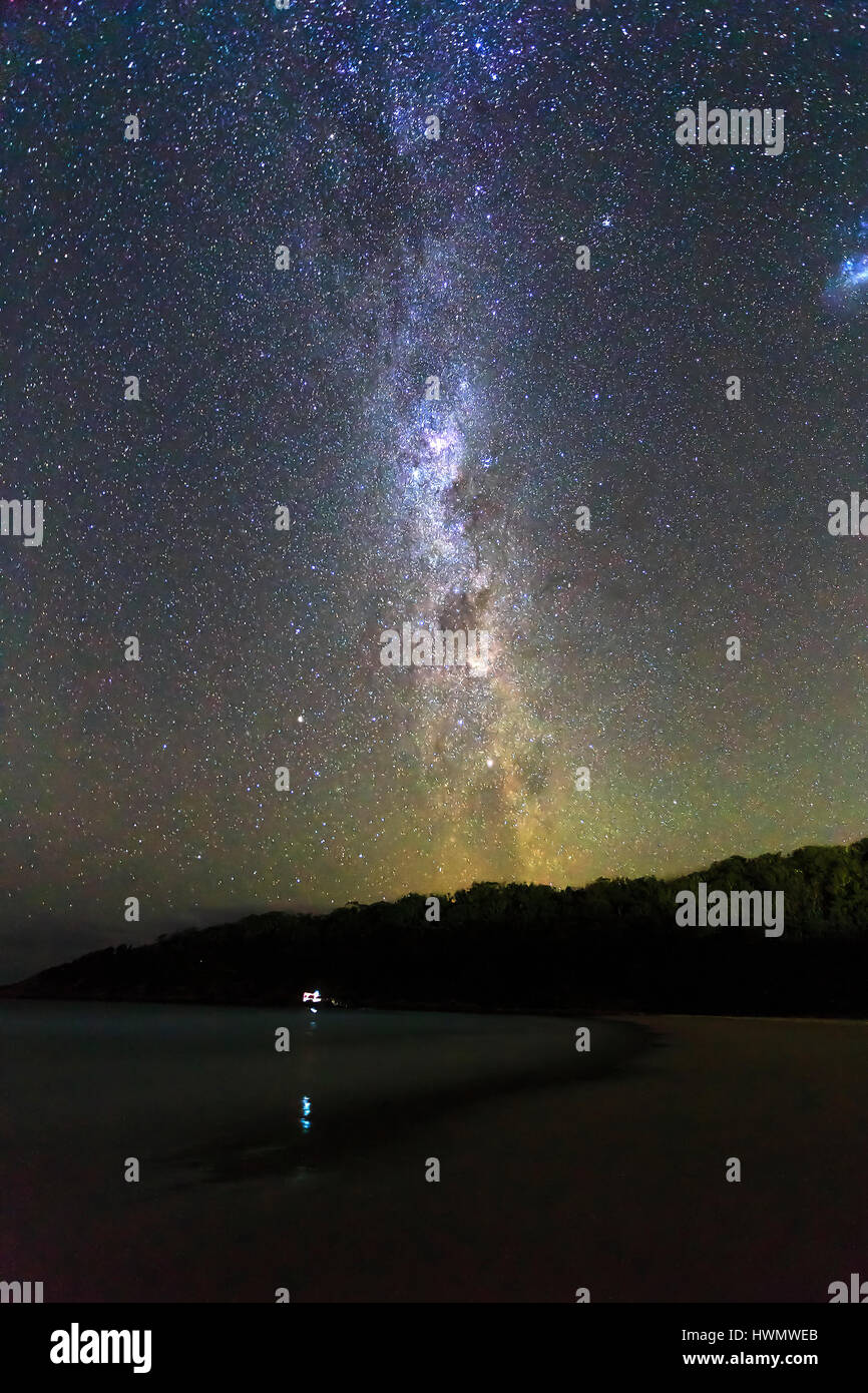 Guardare le stelle del cielo australe a vuoto spiaggia sabbiosa su una tranquilla notte senza nuvole vedendo via lattea e Southern Cross costellazione. Foto Stock