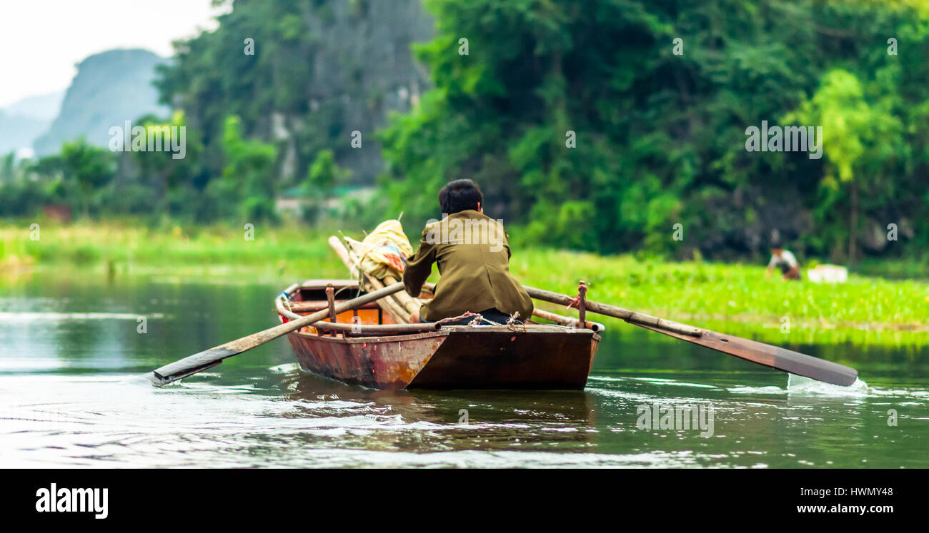 Vista sull'uomo in barca a remi da Nin Binh in Vietnam Foto Stock