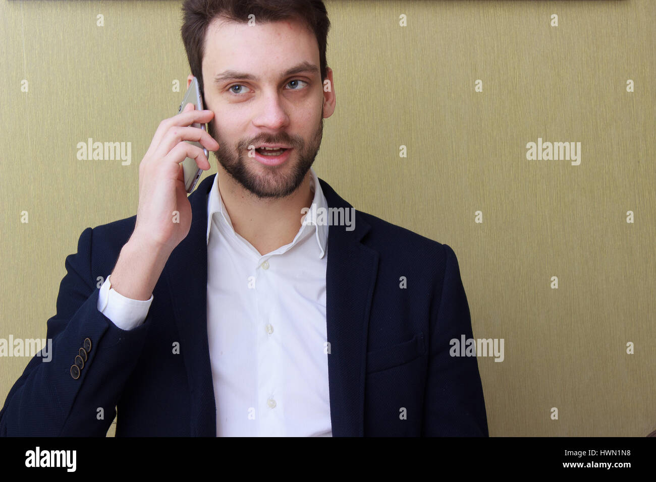 Un giovane imprenditore parlando al telefono cellulare in ufficio Foto Stock