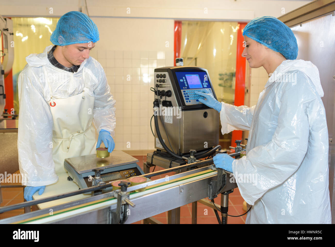 Operatori di fabbrica impostazione apparecchiatura sulla linea di produzione Foto Stock