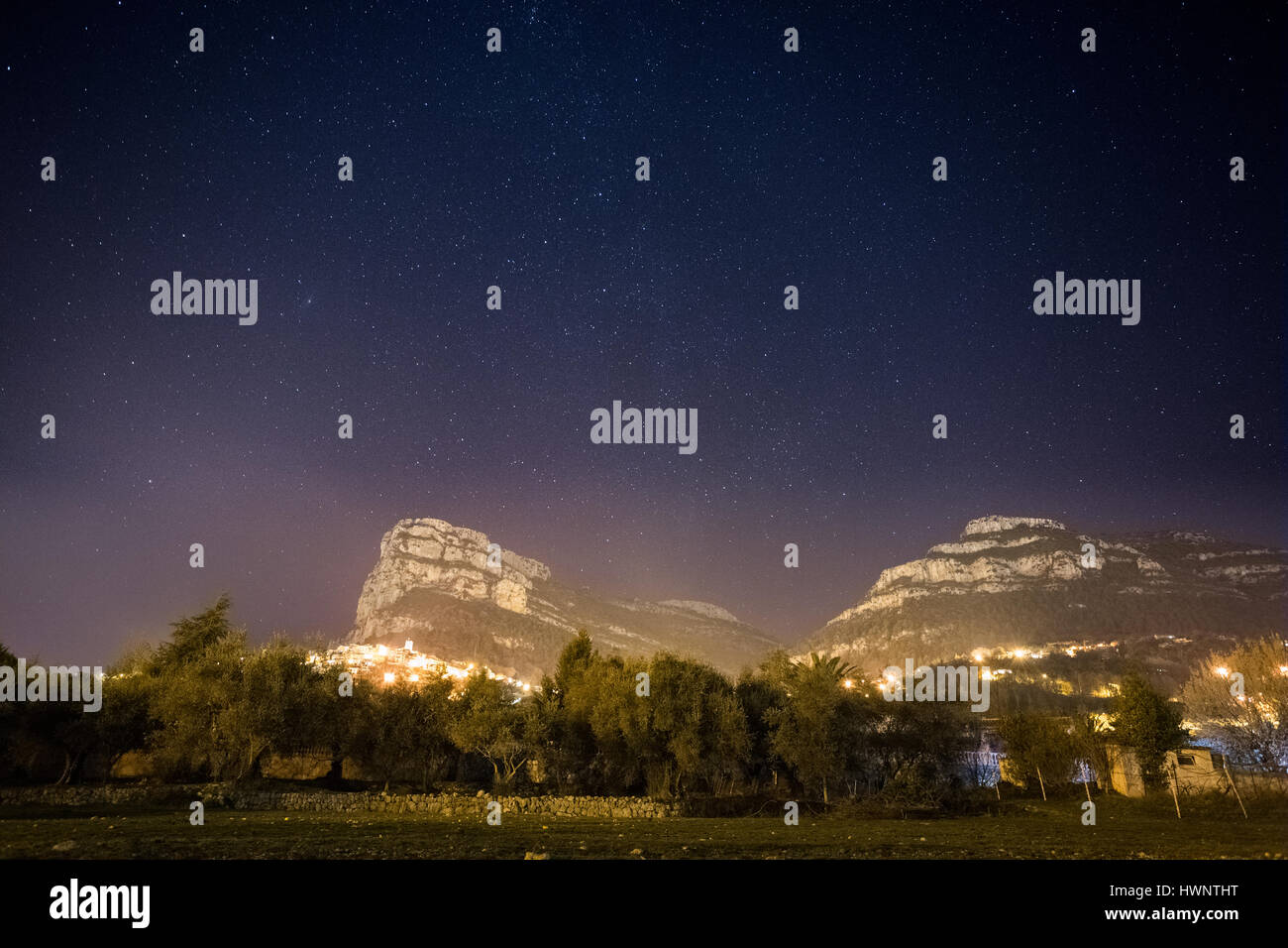 Foto orizzontale di una scena notturna presentando montagne sotto un cielo pieno di stelle Foto Stock