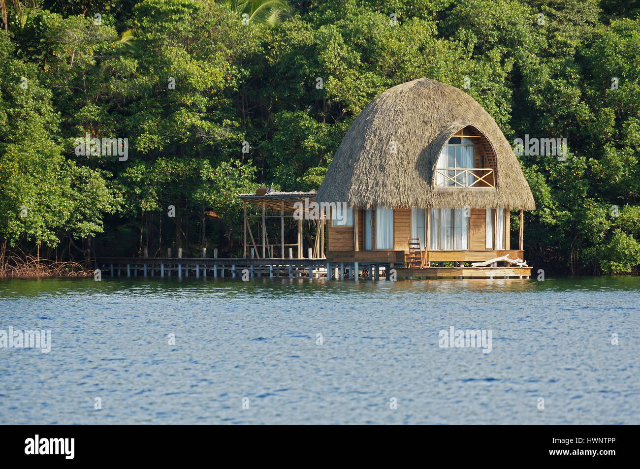 In legno bungalow Overwater con tetto di paglia, architettura tropicali, Bocas del Toro, Mar dei Caraibi, America centrale e di Panama Foto Stock
