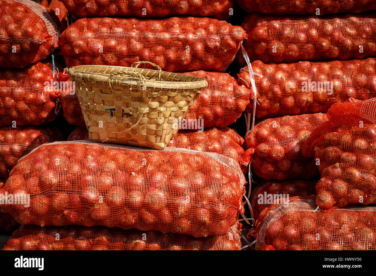 Impilate le cipolle e un cestello nei mercati di Mandalay, Myanmar Foto Stock