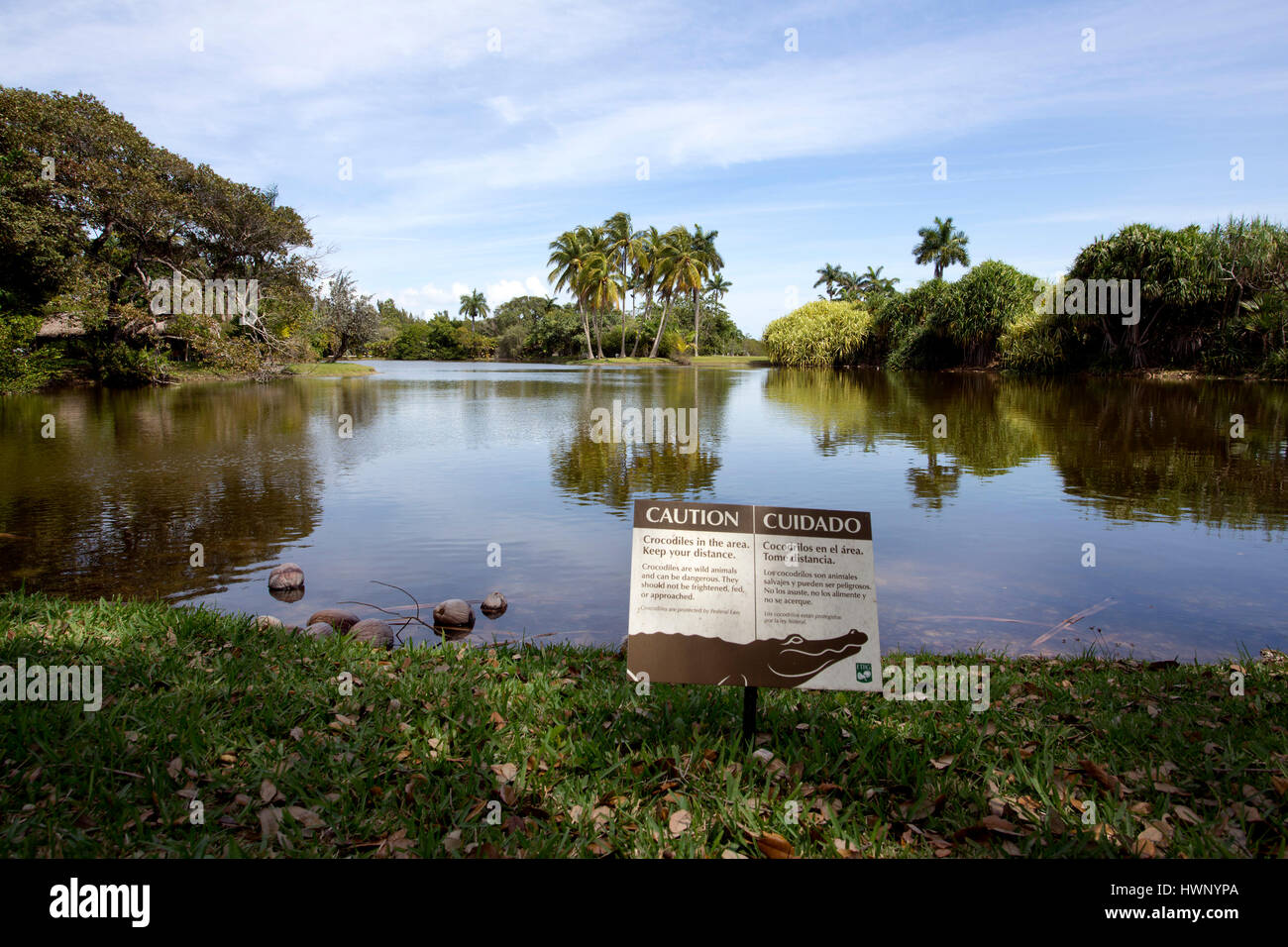 Avvertimento cartello di coccodrillo accanto allo stagno, Fairchild Tropical Botanic Garden in Coral Gables, Florida Foto Stock