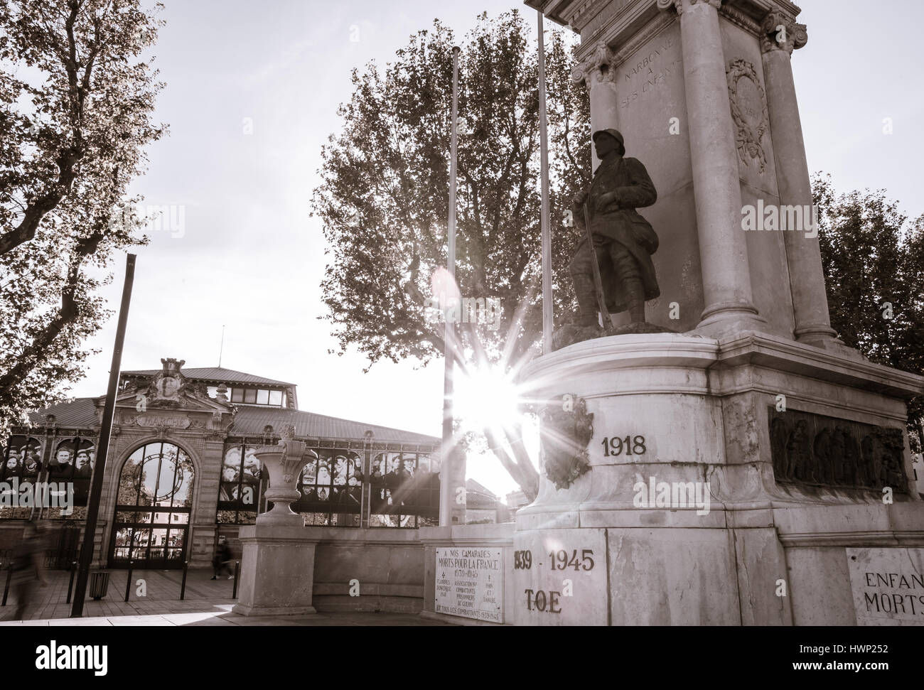 Lens Flare illumina "nostri compagni sono morti per la Francia " Guerra Mondiale una statua commemorativa del soldato con il market hall in background sul lato del Canal de Foto Stock