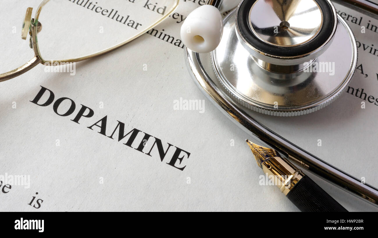 Carta con parola dopamina e un libro. Concetto di ormoni. Foto Stock