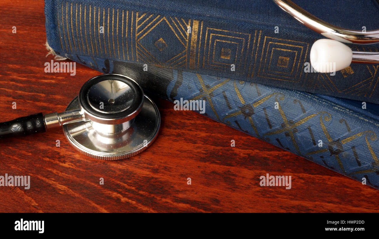 Libro vintage e stetoscopio. Assistenza sanitaria e istruzione medica concetto. Foto Stock