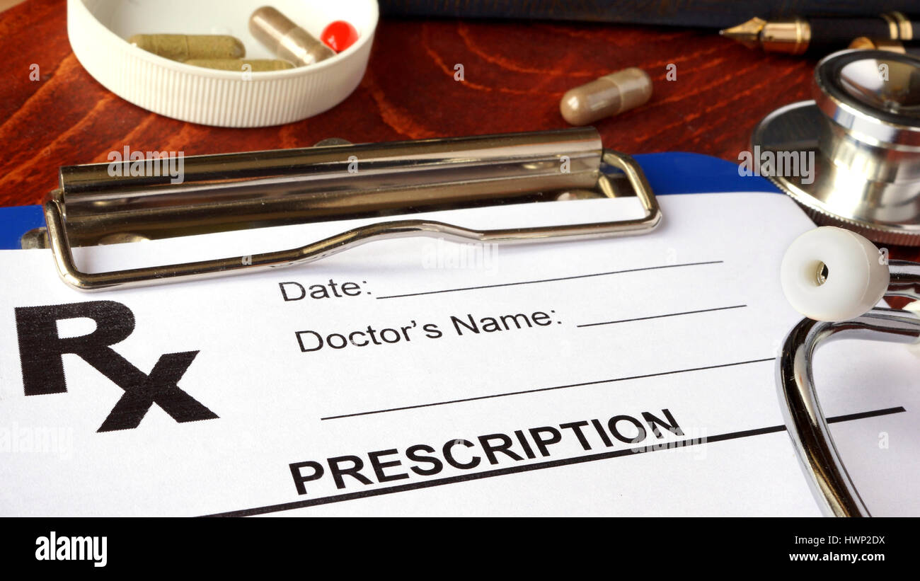 Modulo di prescrizione in un ospedale e pillole e capsule. Foto Stock
