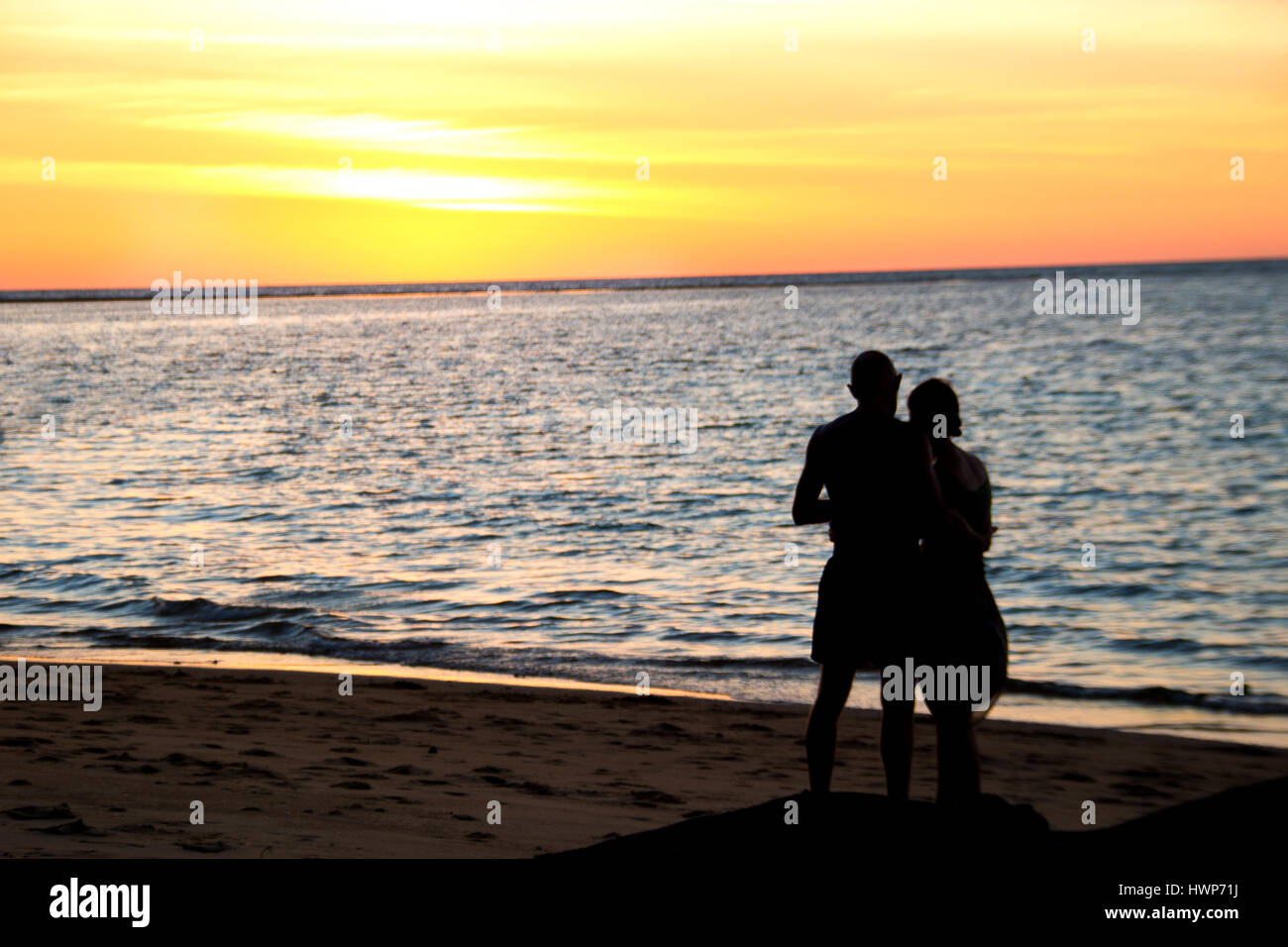 Silhouette amore romantico uomo e donna abbraccio a vedere il tramonto sulla spiaggia Foto Stock