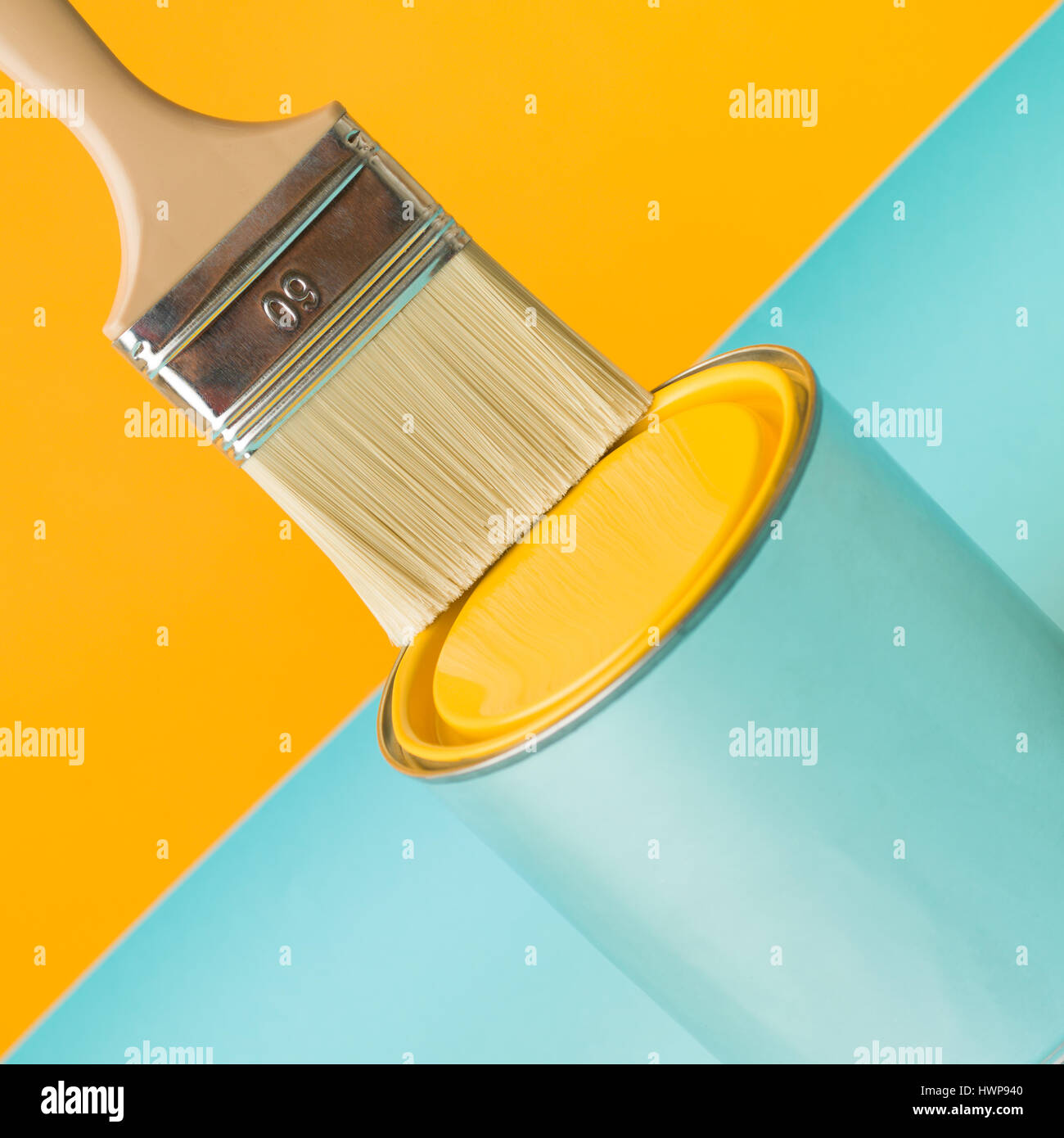 Immagine minima dipinta di fresco sfondo giallo e può con spazzola sul tavolo blu Foto Stock