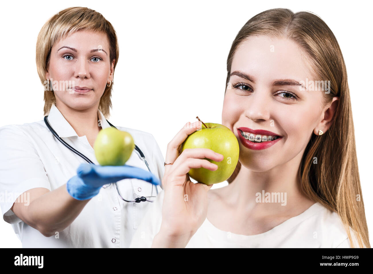 Dentista dando frutti di Apple per la giovane donna con bretelle. Denti sani concetto. Foto Stock