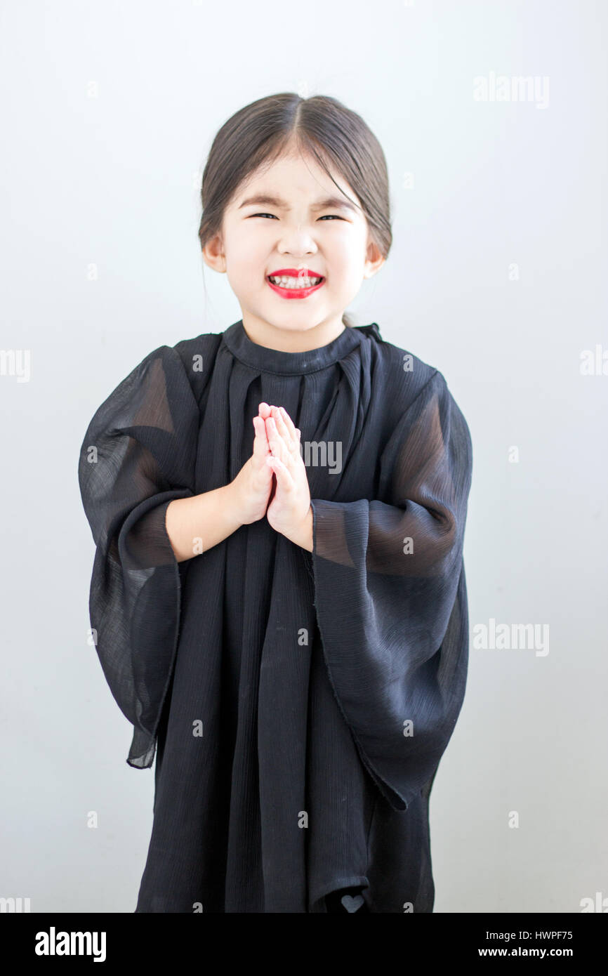 Ragazza asiatica labbro rosso e chiudere la mano a mendicare o mostrare rispetto azione nel lusso abito nero Foto Stock