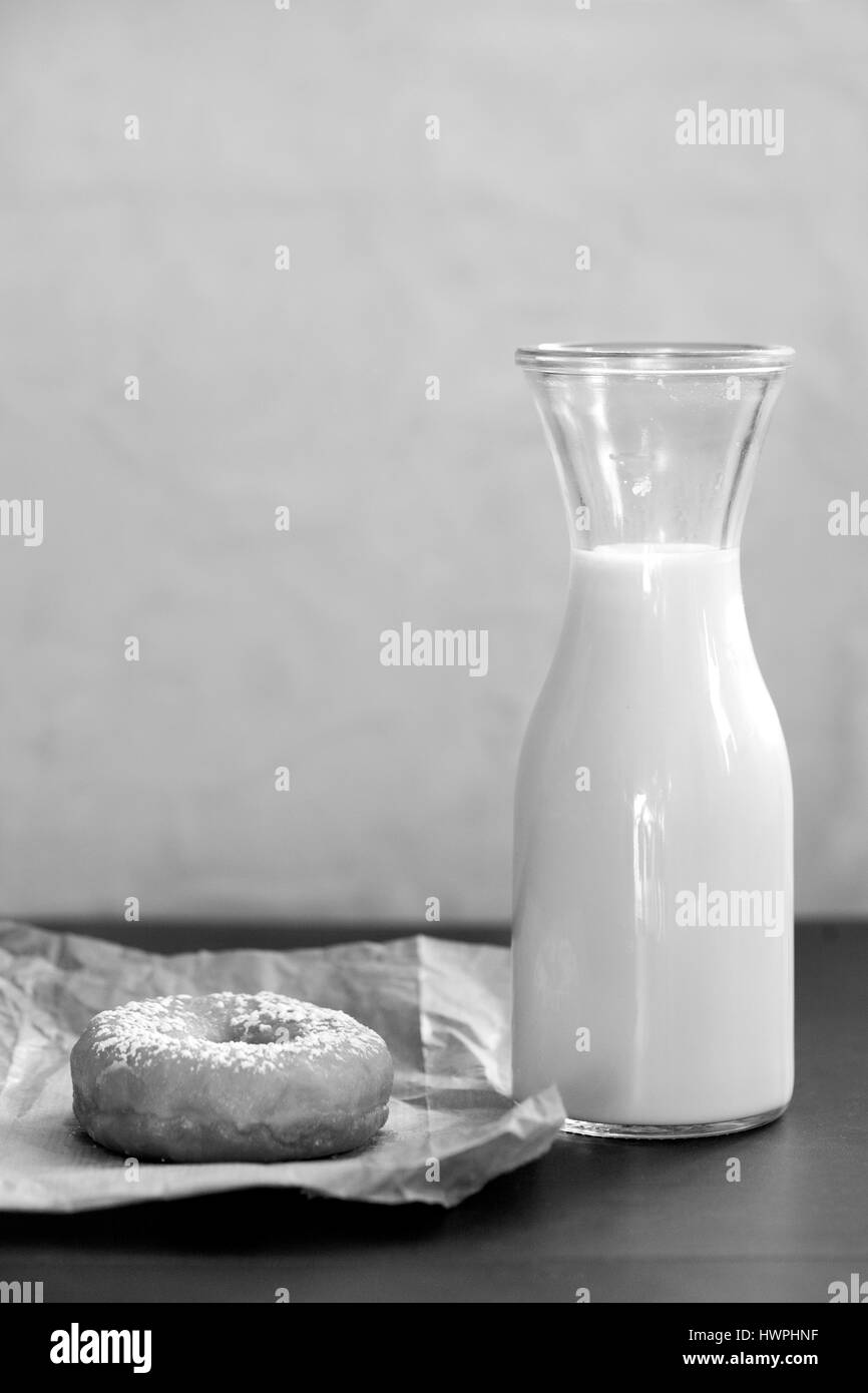 Bottiglia di latte e ciambella in vintage stile retrò. In bianco e nero dell'immagine. Foto Stock