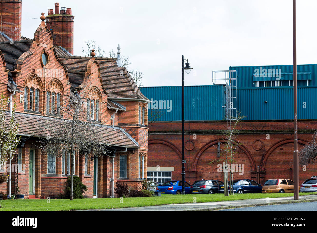 Port Sunlight - un modello di villaggio e borgo nel Metropolitan Borough of Wirral, Merseyside. Case con Unliver fabbrica in background Foto Stock