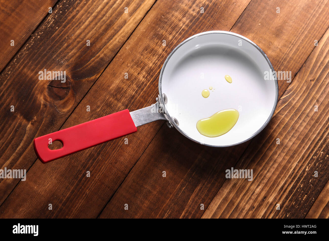 Padella con olio su sfondo di legno Foto Stock