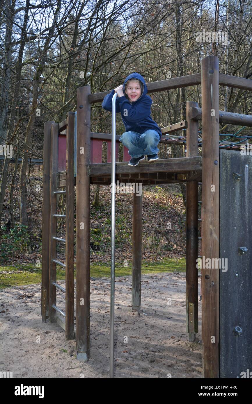 Ragazzo su un ponteggio di arrampicata sul parco giochi Foto Stock