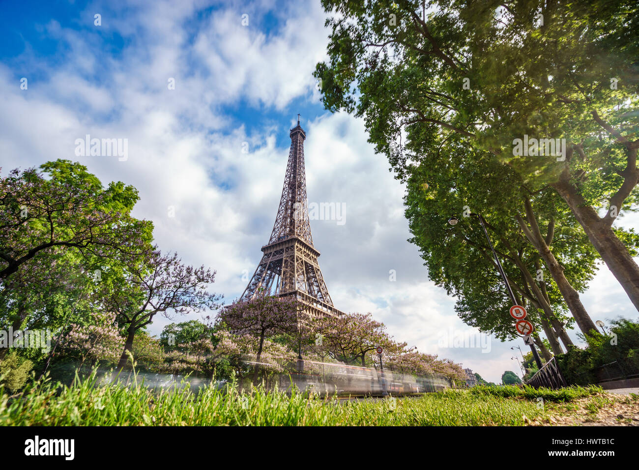La torre Eiffel con auto sentieri e cielo molto nuvoloso Foto Stock