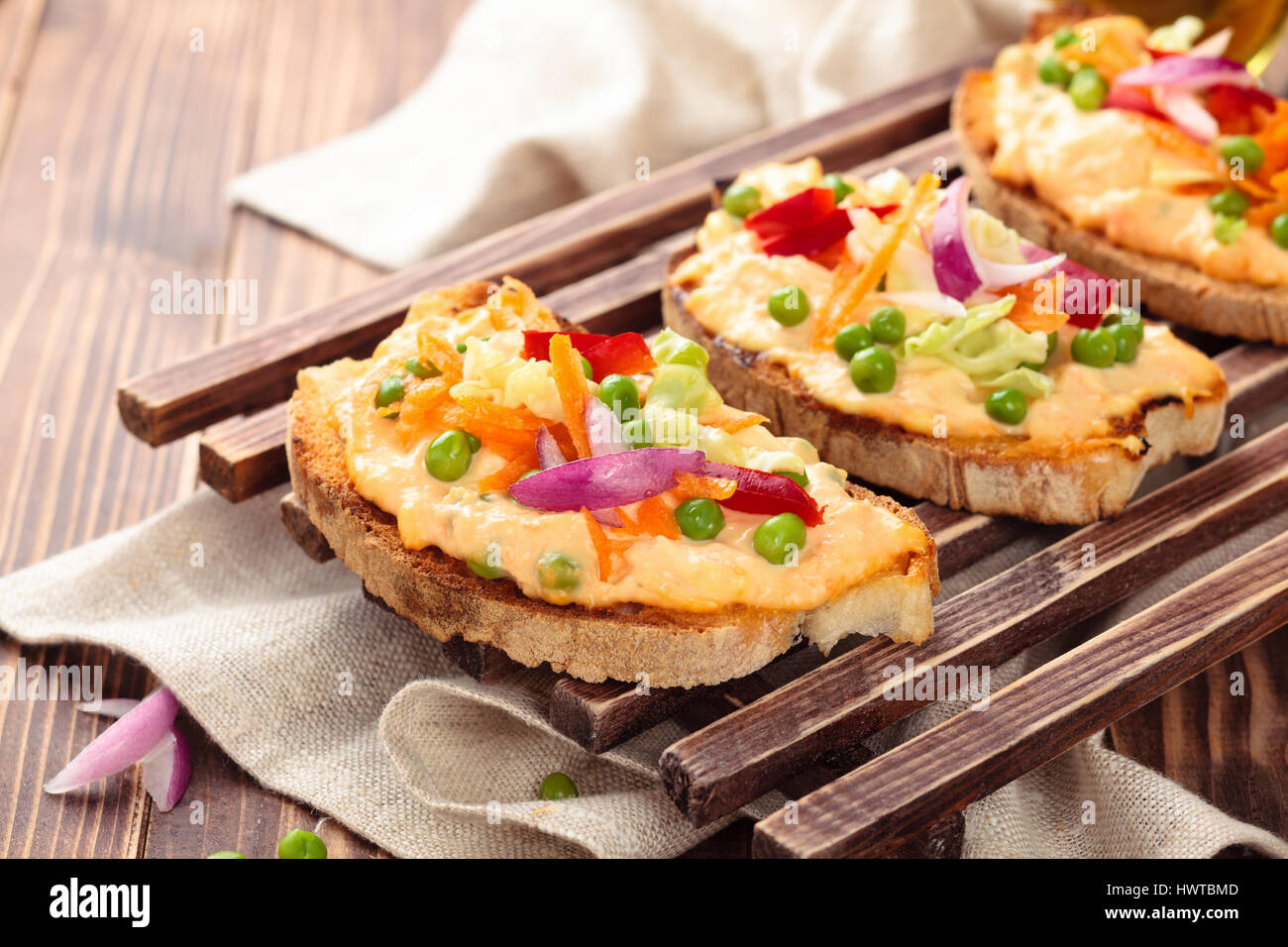 Il cibo italiano. Bruschetta con salsa, piselli, carote, foglie di cavolo e pepe. Foto Stock