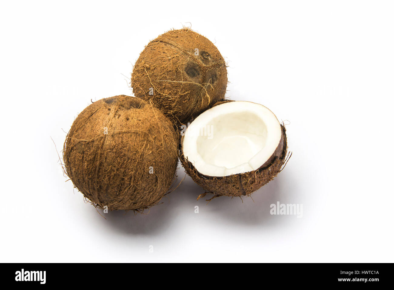 Pezzo di noce di cocco e un incrinato uno su sfondo bianco Foto Stock
