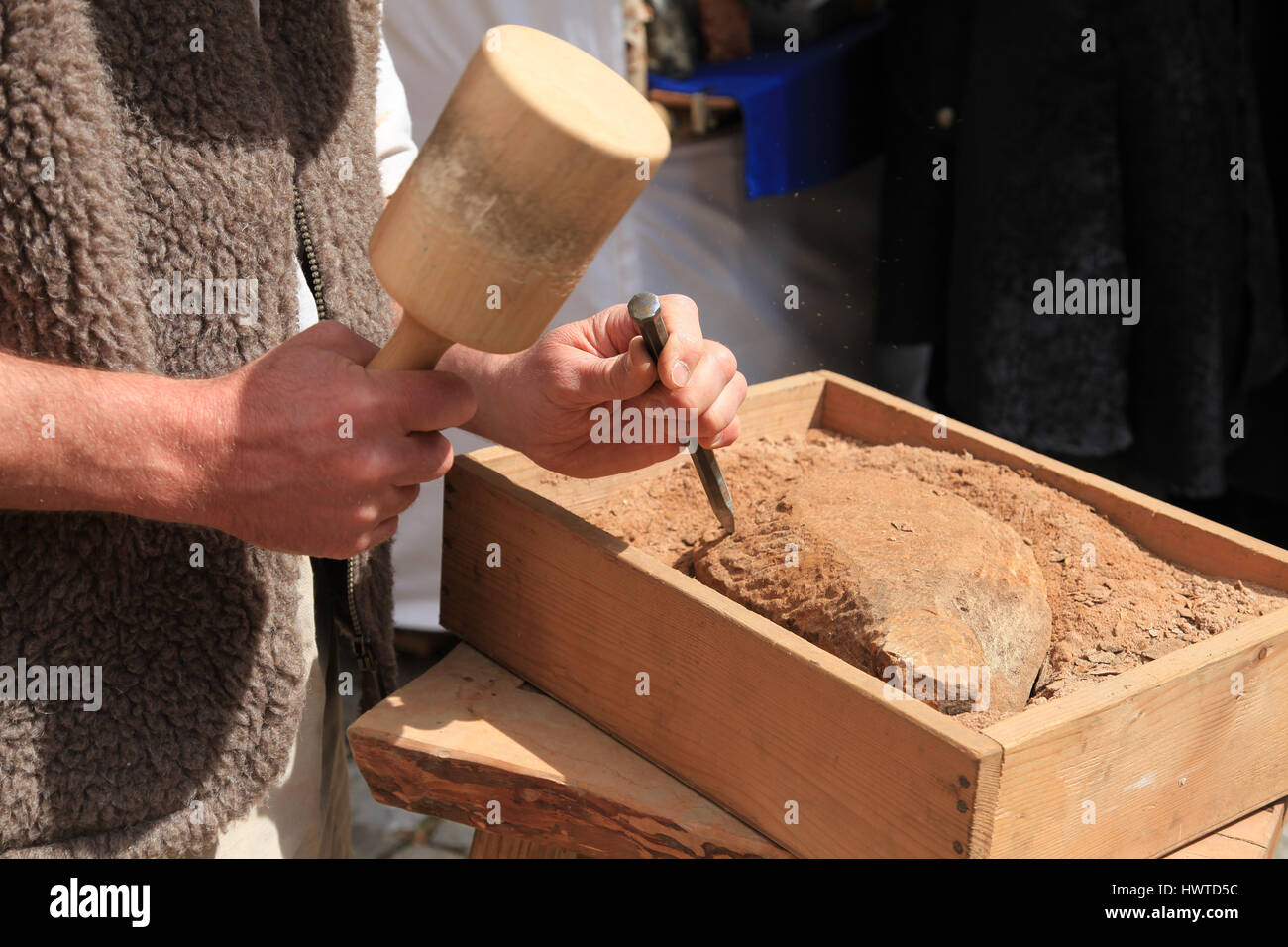 Le mani di un scalpellino con martello e scalpello a lavoro Foto Stock