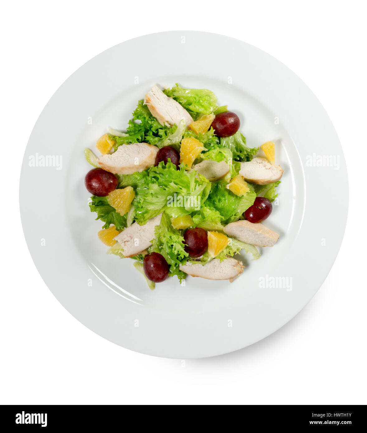 Insalata con uva e fette di pollo isolati su uno sfondo bianco. Foto Stock