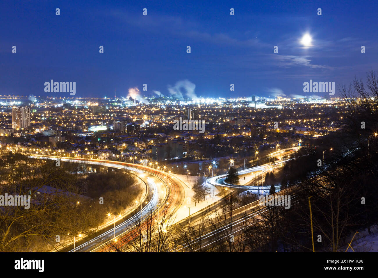 Guardando verso Hamilton della zona industriale dalla Scarpata del Niagara, (Hamilton Montagna) durante la notte sotto una luna piena. Hamilton, Ontario, Canada. Foto Stock