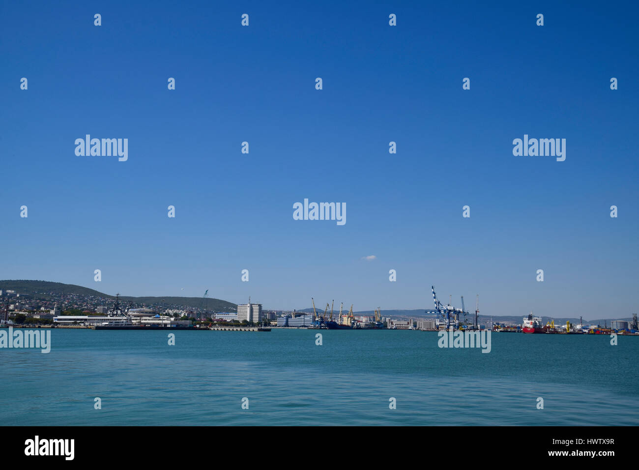 Porti marittimi internazionali. La porta di carico con gru portuali. Baia Mare e costa di montagna. Foto Stock