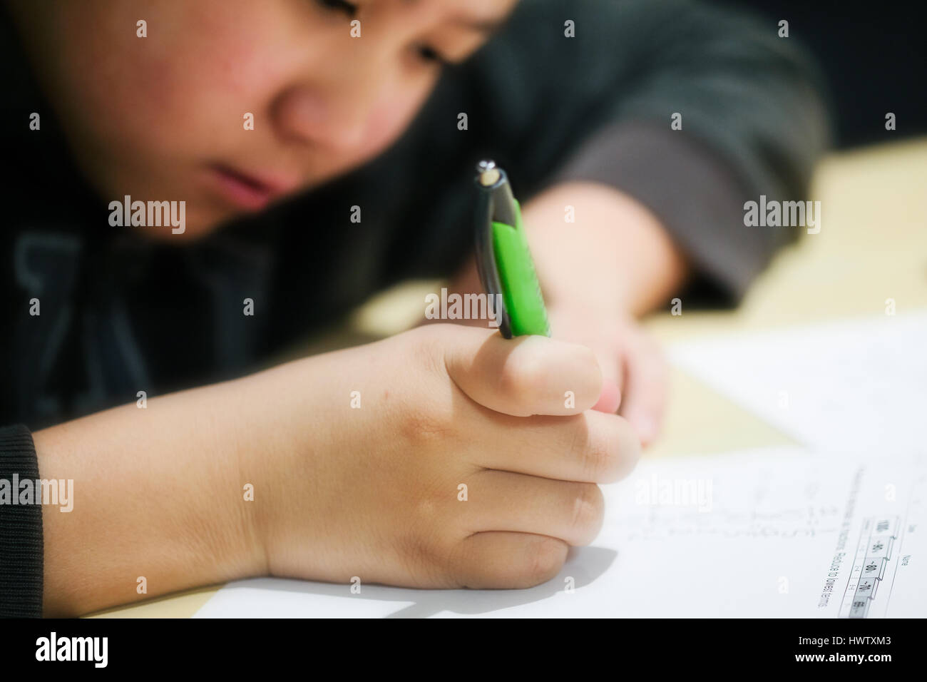 Una vista ravvicinata di un giovane ragazzo di fare i compiti di scuola Foto Stock