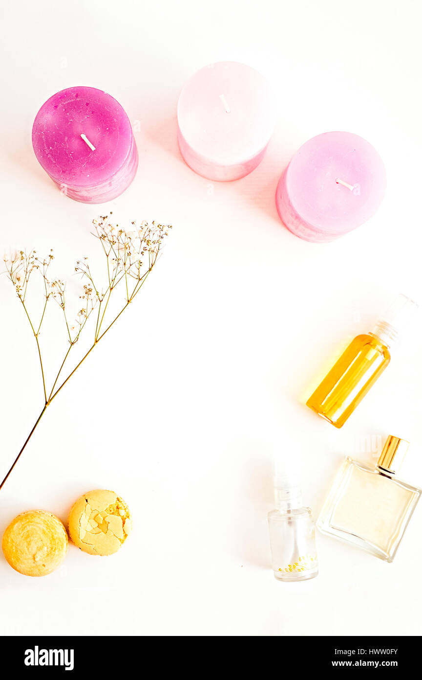 Cosmetici naturali, oli biologici per il viso, i capelli e il corpo, amaretti, rosa candele, fiori. Piatto per laici beauty blog su un bianco. Spazio di copia Foto Stock