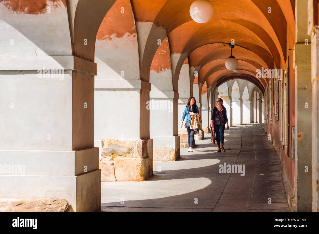 Centro storico di Praga, vista di due giovani donne che camminano attraverso un portico nel quartiere storico di Hradcany di Praga, Repubblica Ceca. Foto Stock