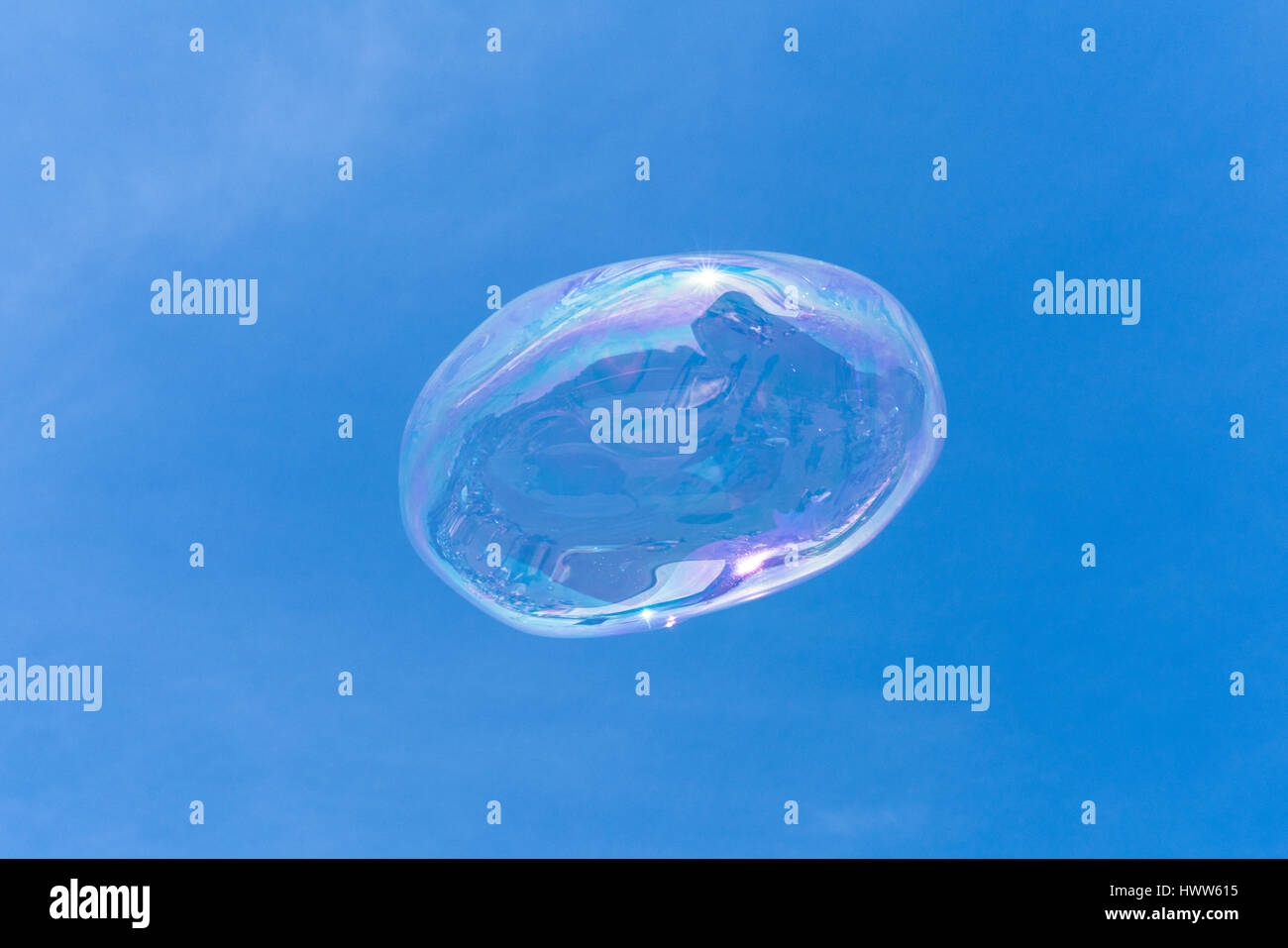 Una bolla di sapone galleggianti nel cielo blu con riflessioni Foto Stock