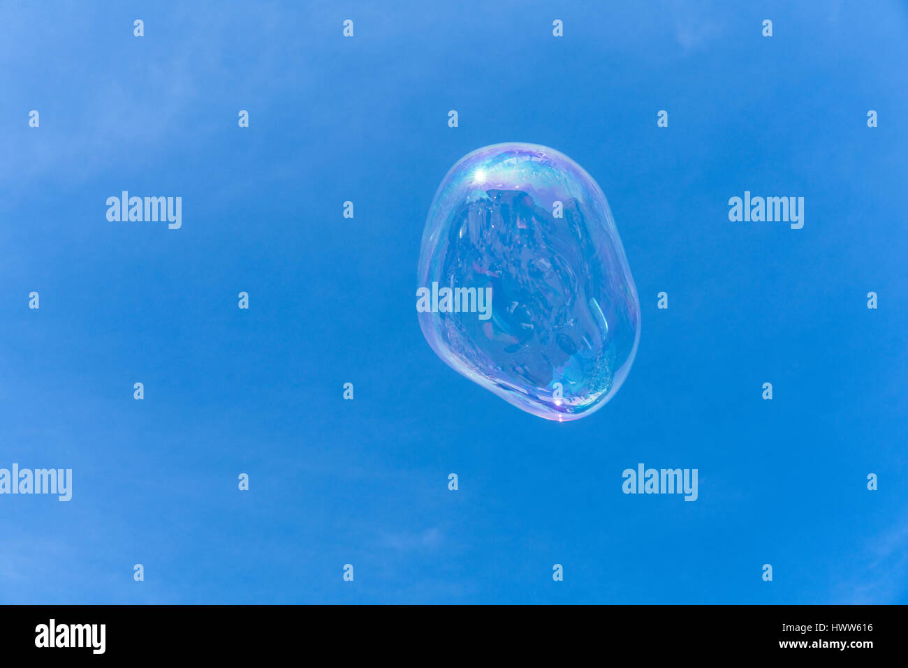 Una bolla di sapone galleggianti nel cielo blu con riflessioni Foto Stock